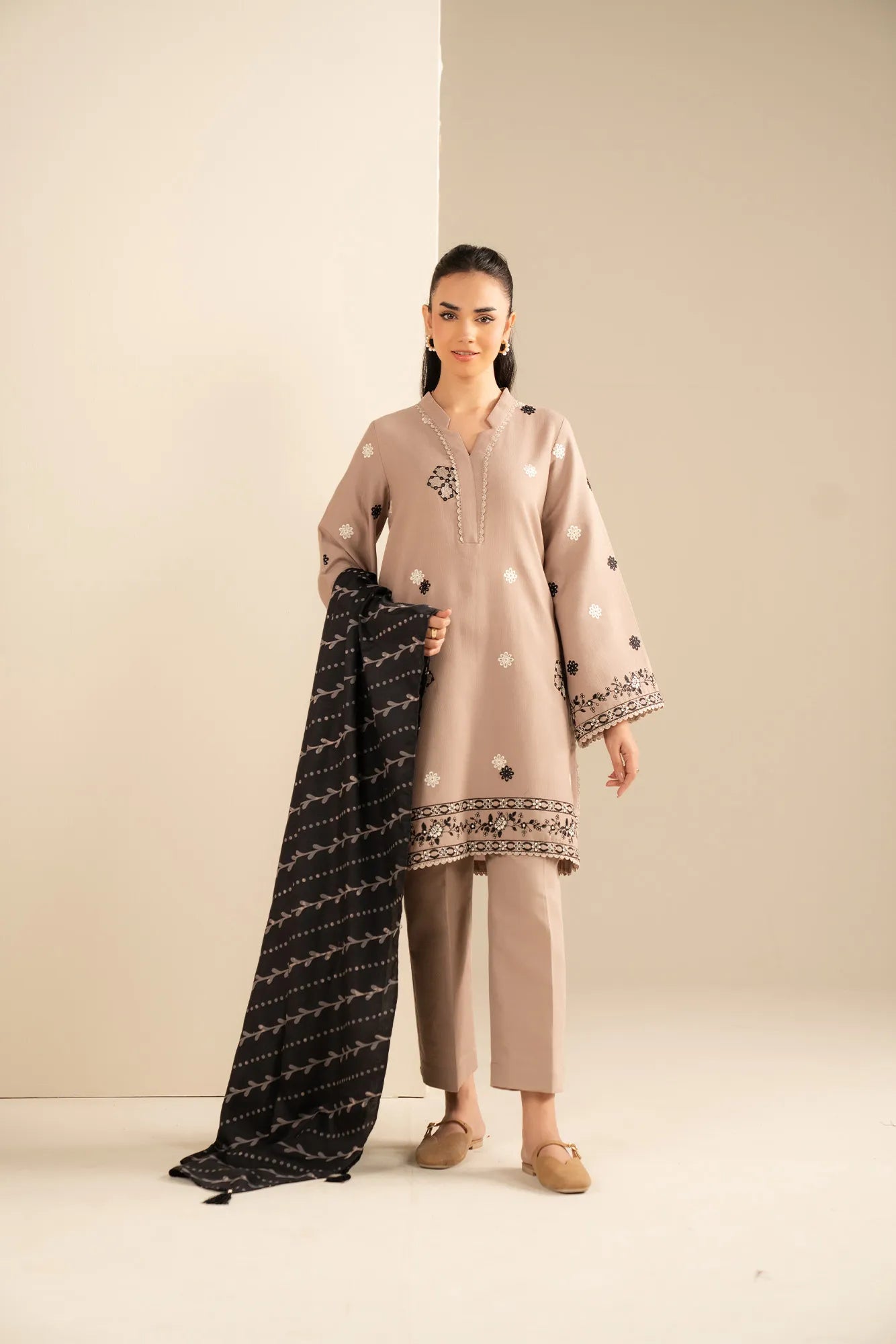 Front view of beige khaddar suit with black embroidery and printed shawl