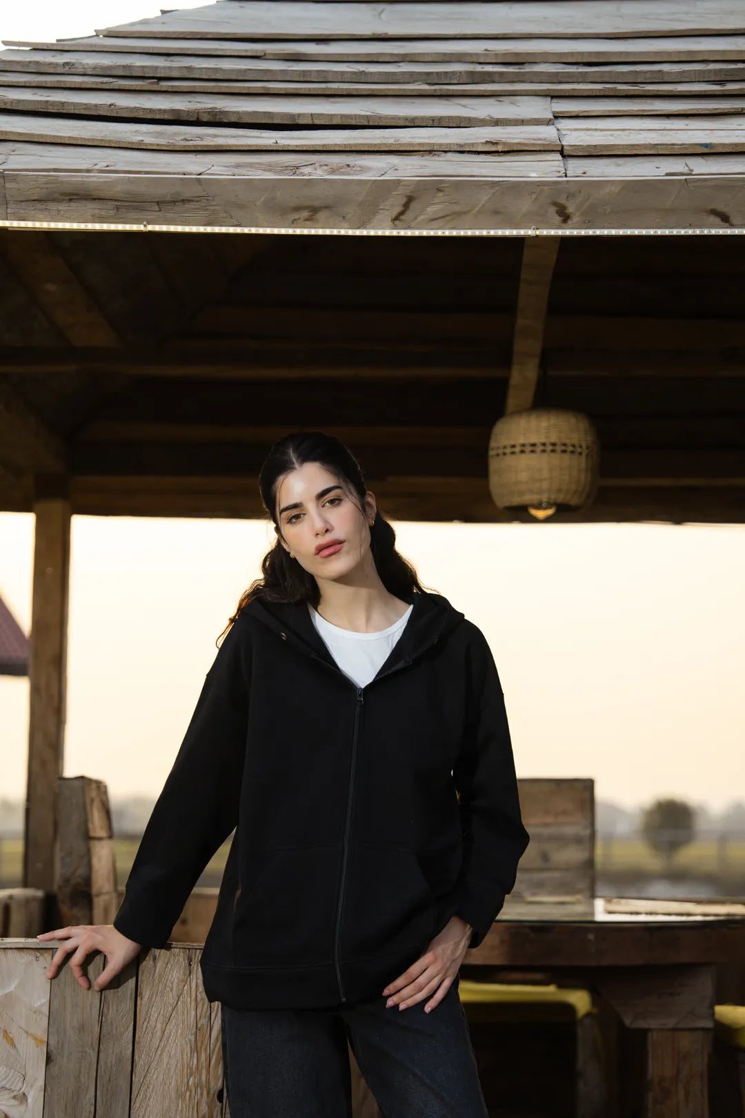 Front view of black cotton fleece zip hoodie on model