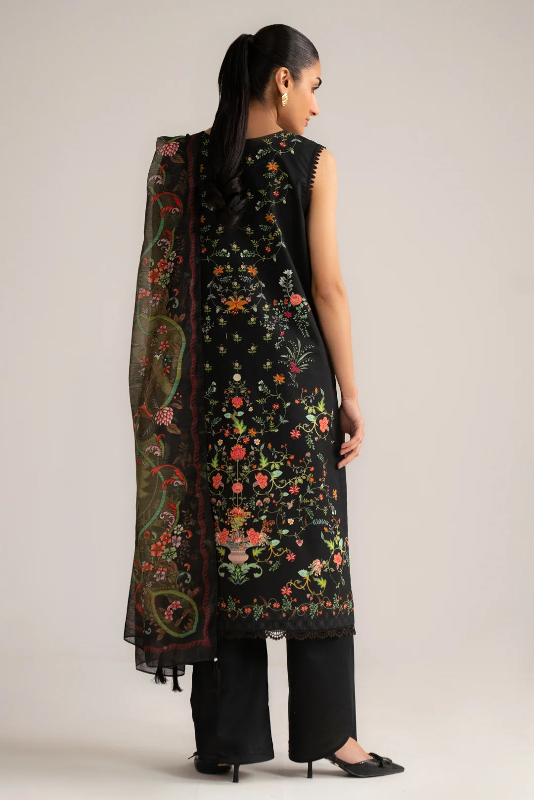 Full-length angled pose of black printed 3 piece suit with coordinated dupatta