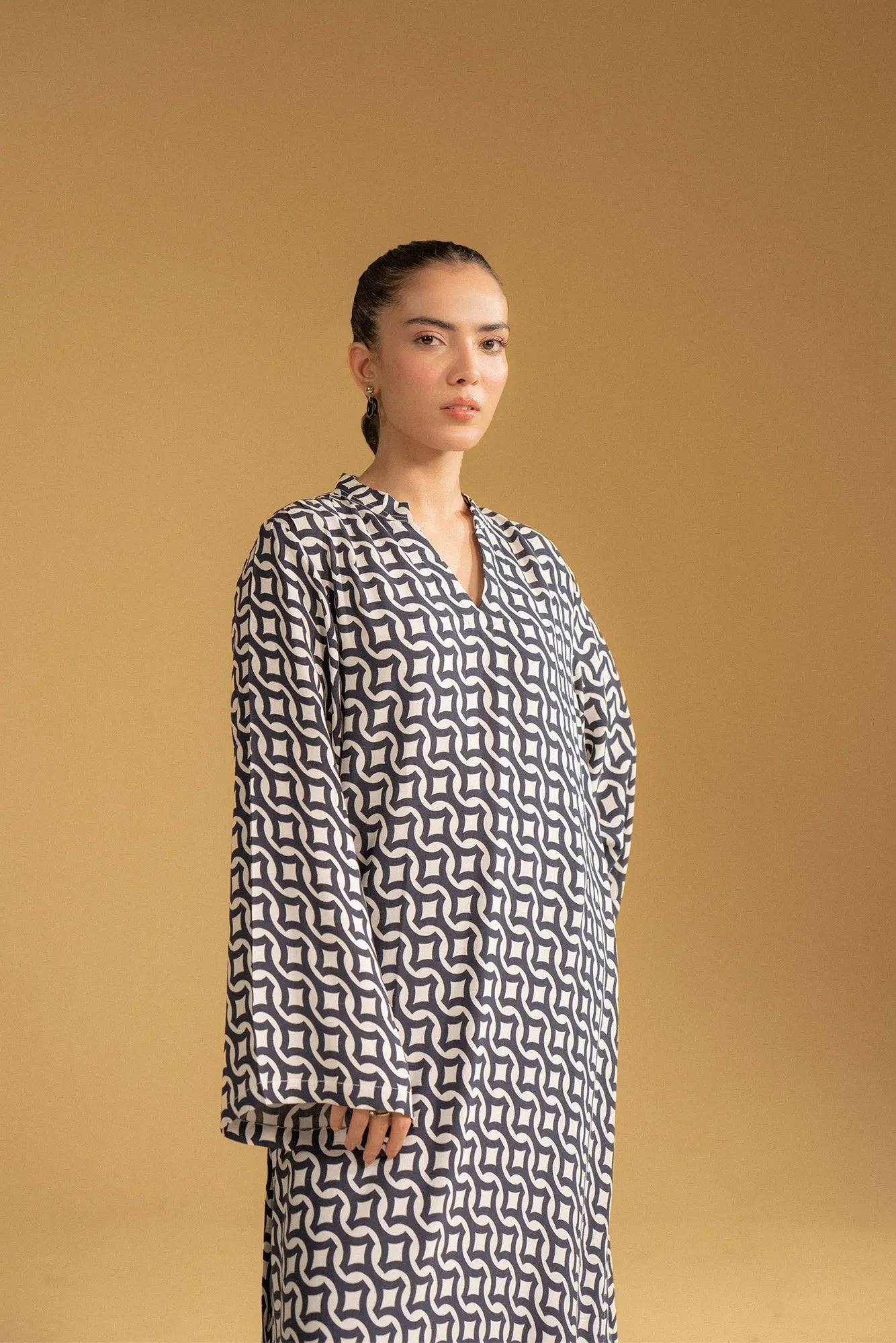 Full-length view of a modern kaftan with a black and white pattern, perfect for a modest look in Pakistan.