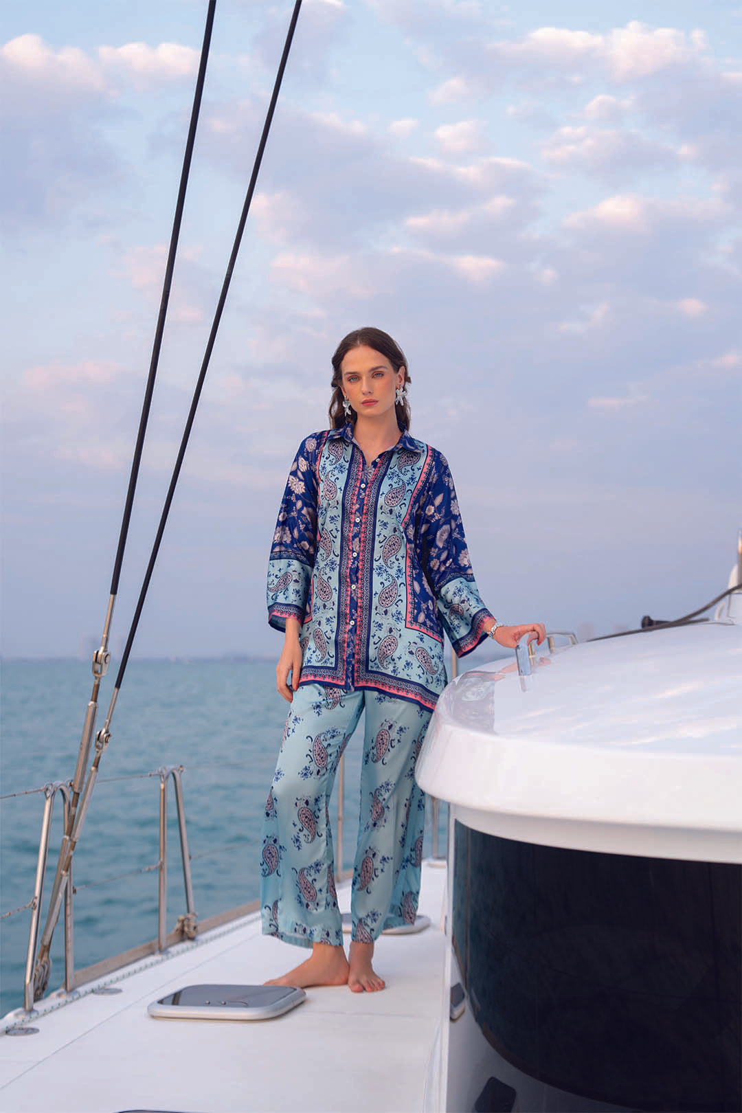 Full-length view of blue and sea green printed poly satin co-ord set on a boat