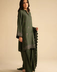 Full-length view of green embroidered linen suit with trousers and dupatta drape, showing overall silhouette.