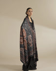 Full-length view of grey printed herringbone shawl styled over a black outfit, showcasing detailed print