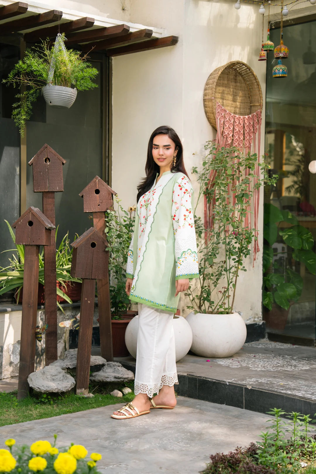 Full-length view of light green printed cambric shirt with white trousers in garden setting