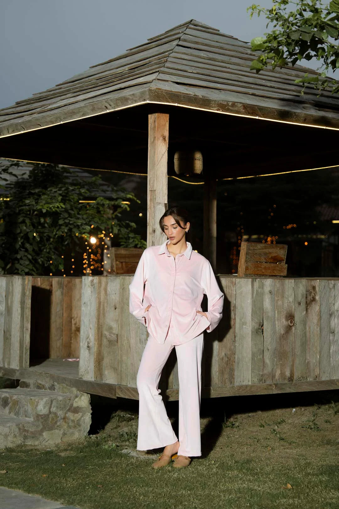 Full-length view of soft pink velvet co-ord set styled with a button-down top and straight pants