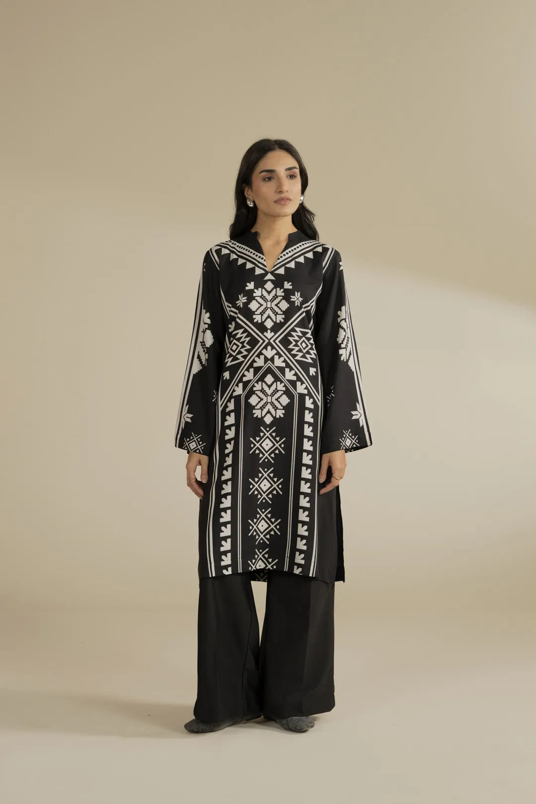 Half-body photo focusing on the neckline and front panel print on the black linen shirt