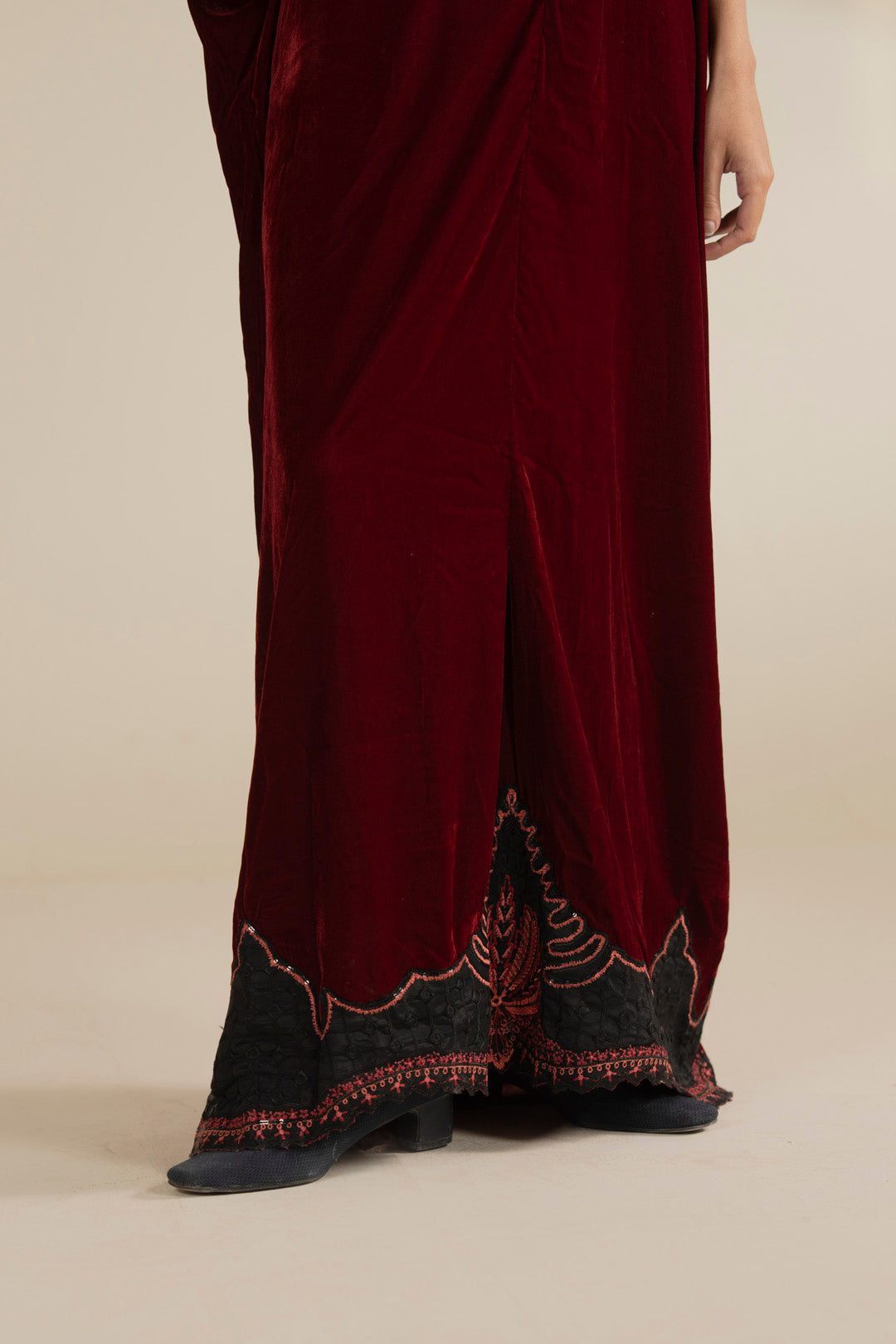 Hem/border close-up capturing the embroidered accents near the lower edge.