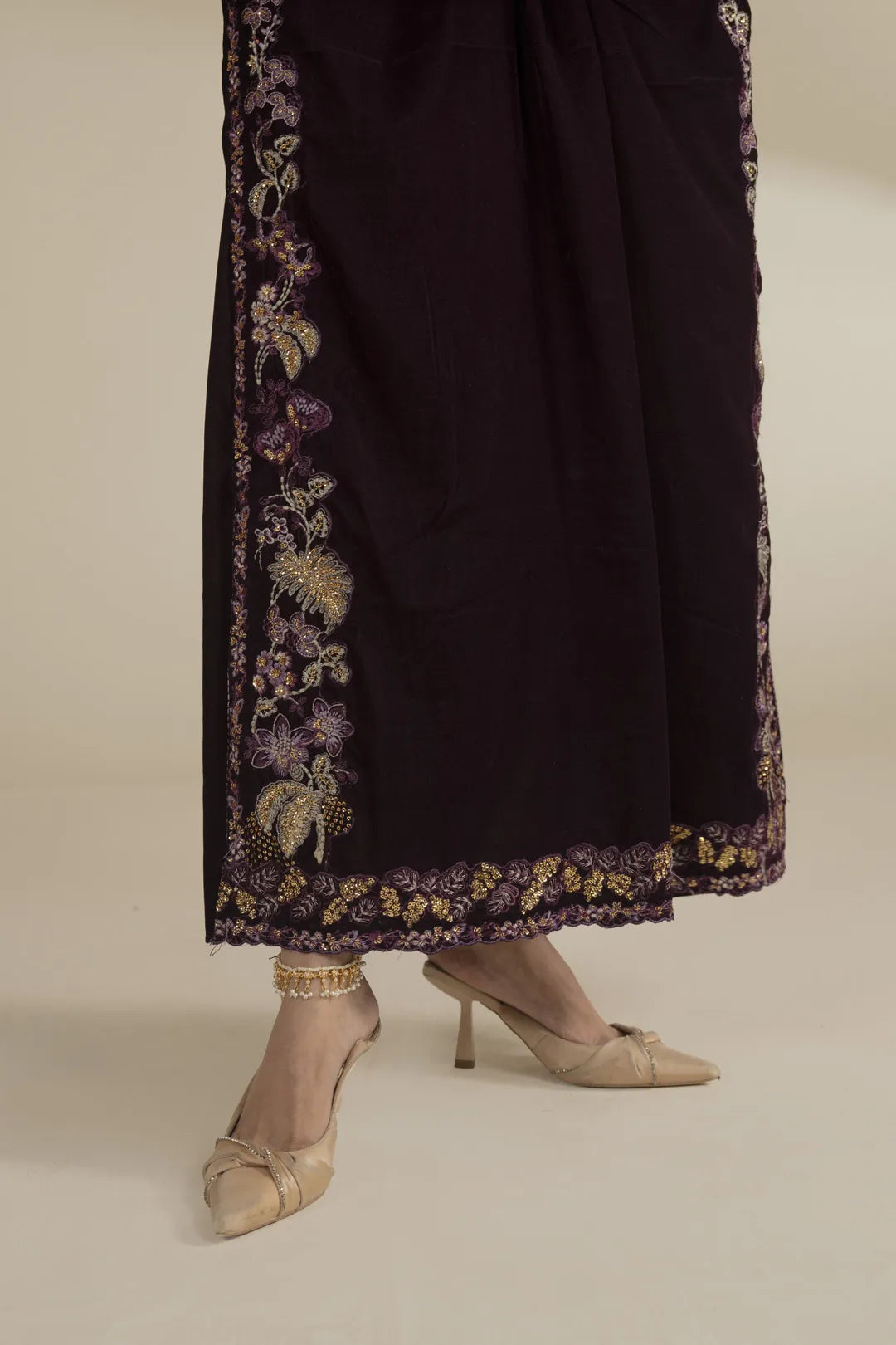 Lower half view of velvet kaftan showing embroidered side/hem border and drape