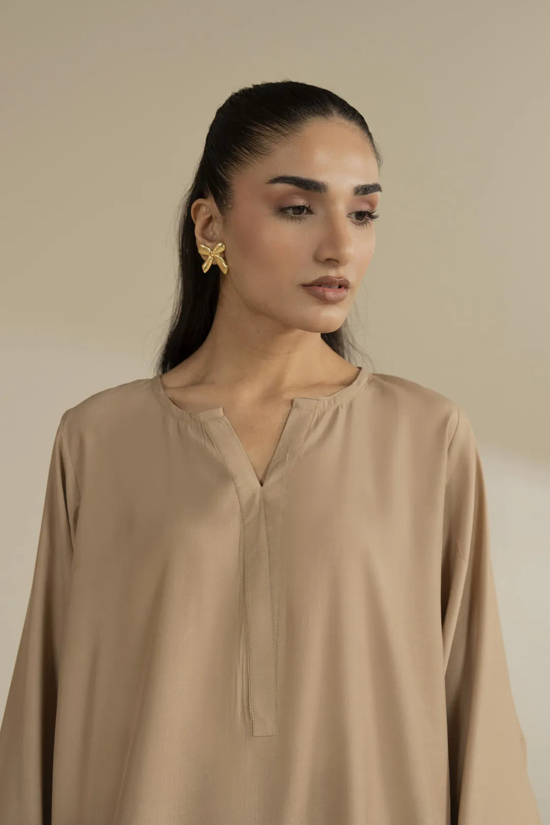 Lower half view showing beige straight trousers paired with embroidered kurta hem.