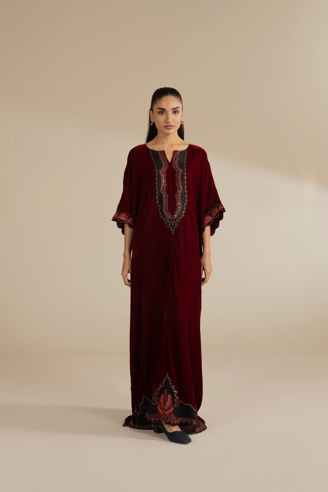 Maroon velvet kaftan with embroidered neckline and wide sleeves, styled as a full-length festive look.