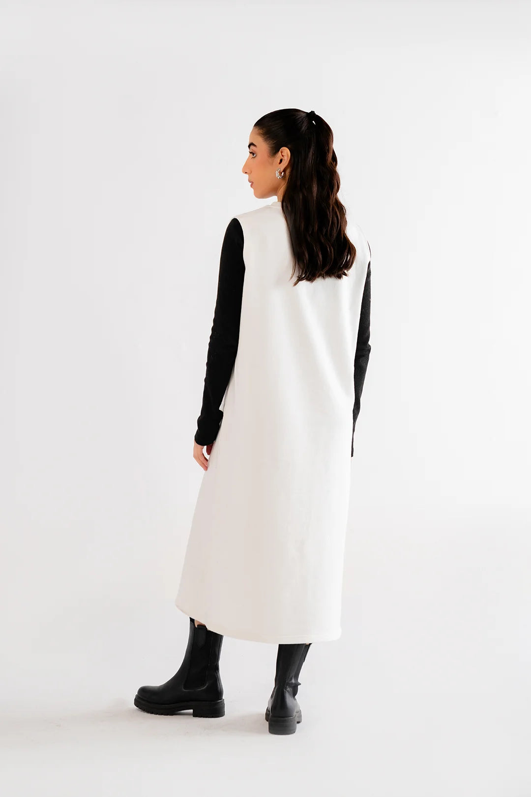 Minimalist white sleeveless maxi dress paired with black boots and black inner sleeves for contrast.