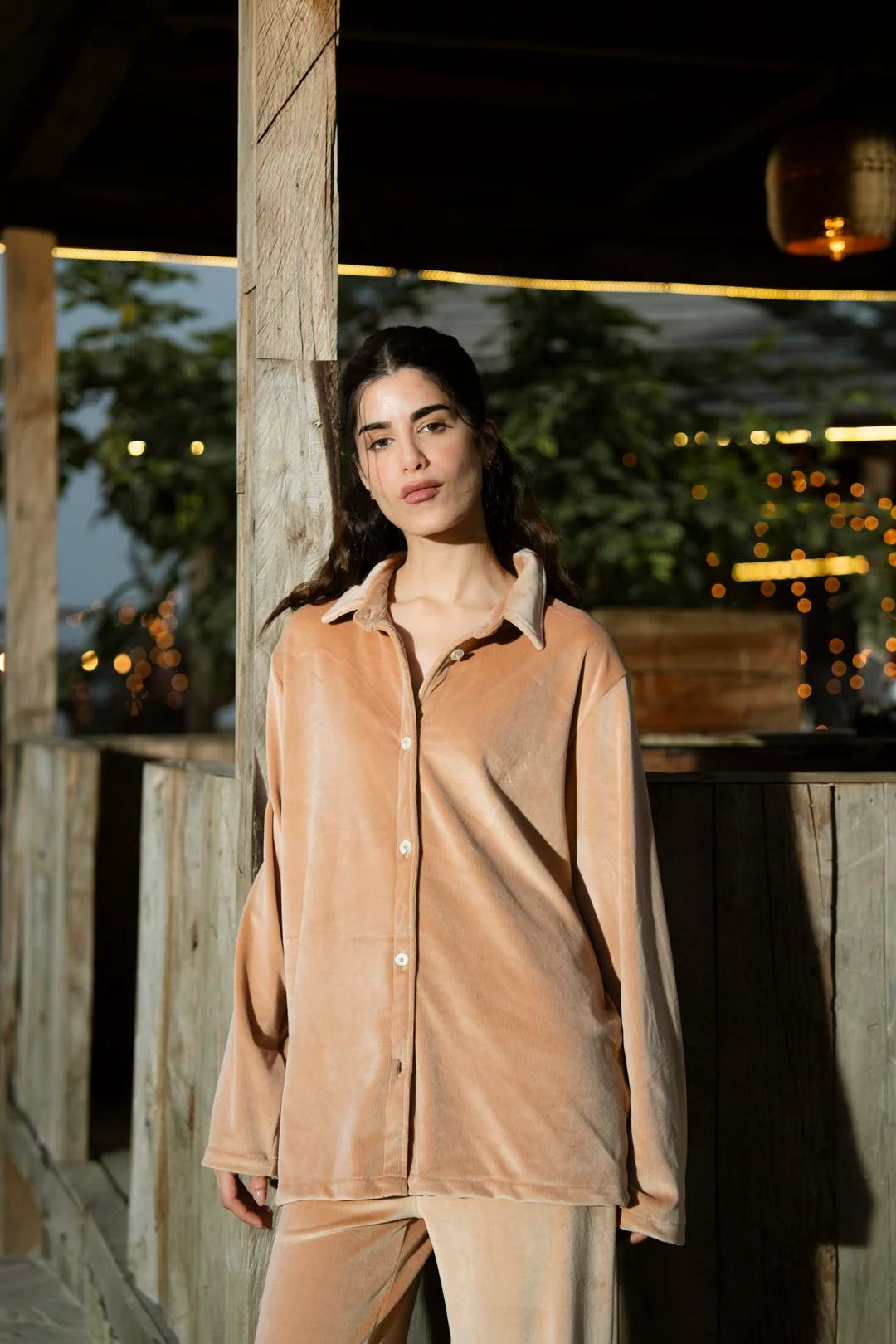 Model in camel velvet co-ord set standing outdoors, front pose highlighting velvet sheen.