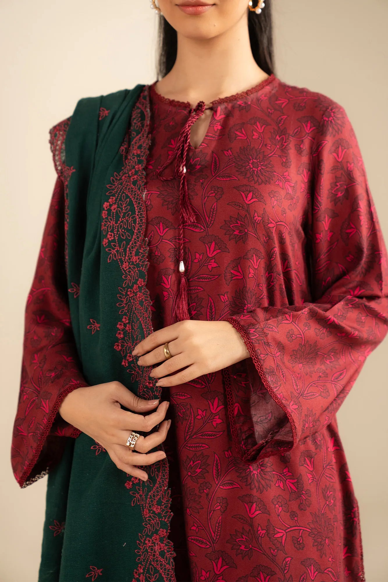 Model wearing Marina suit — wine red long kurta with full sleeves and contrasting forest green dupatta with embroidered border.