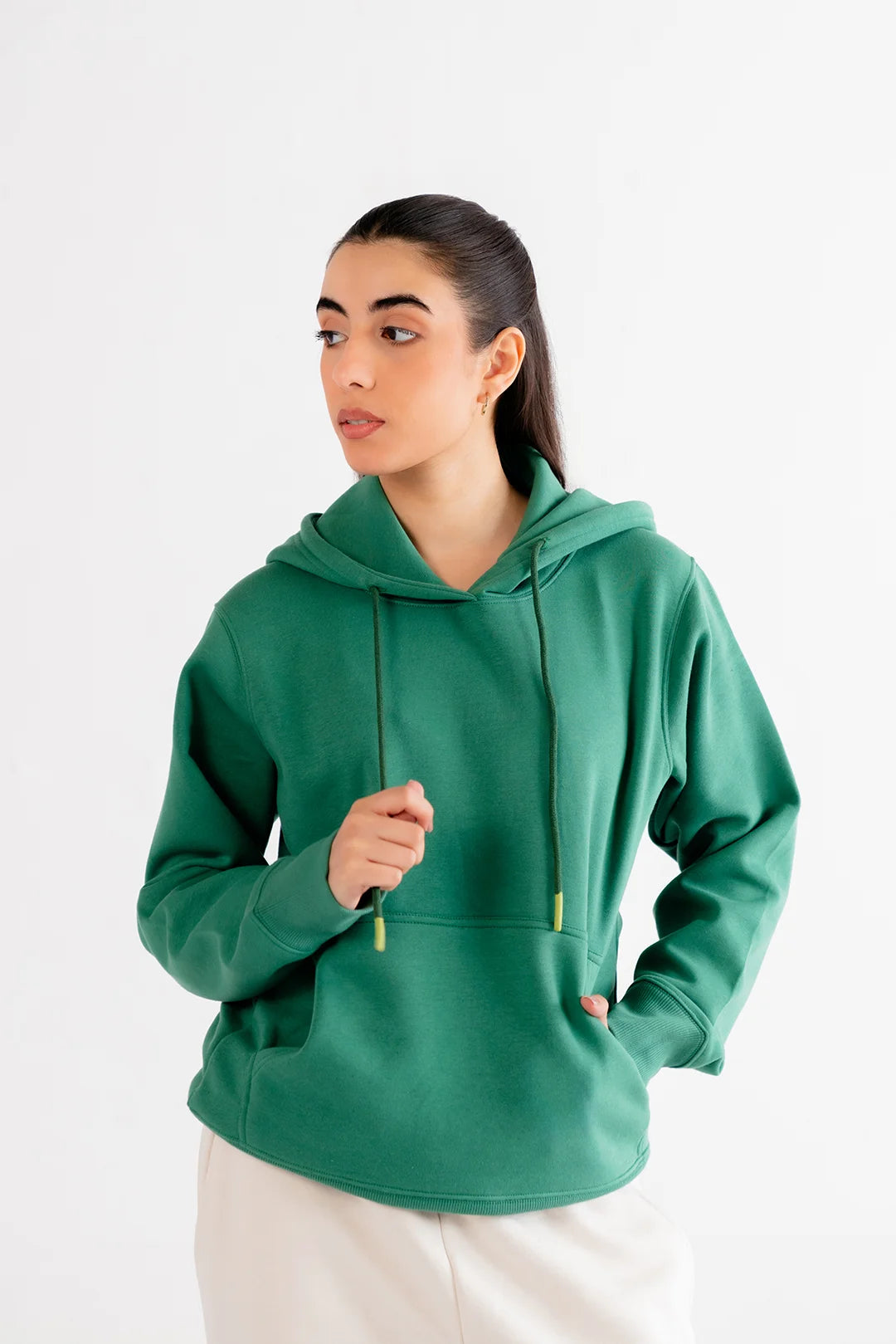 Model wearing a classic green hoodie with a front pouch and drawstring hood, showcasing a cozy wardrobe essential.