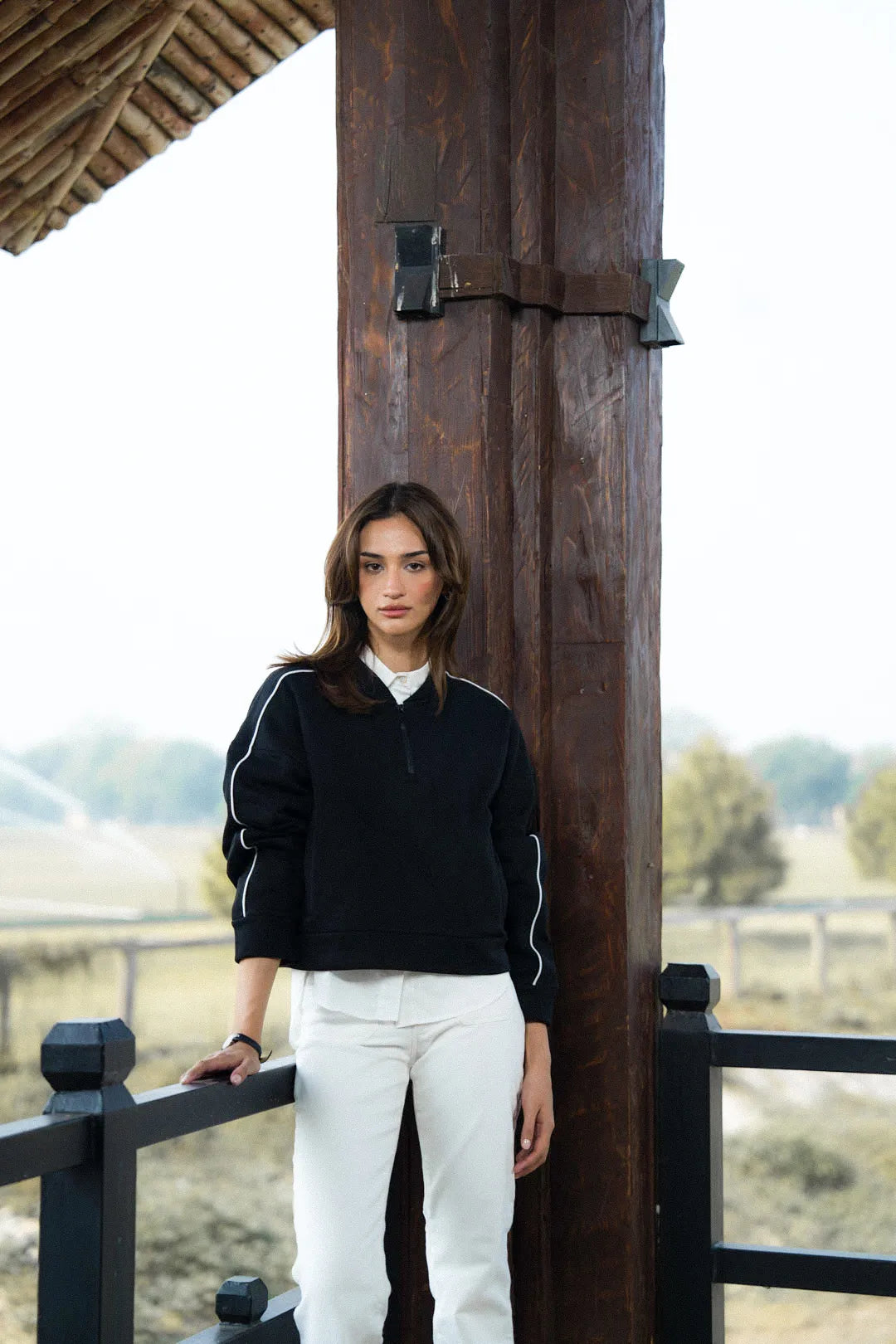 Model wearing black blended fleece sweatshirt with sleeve stripe, front view