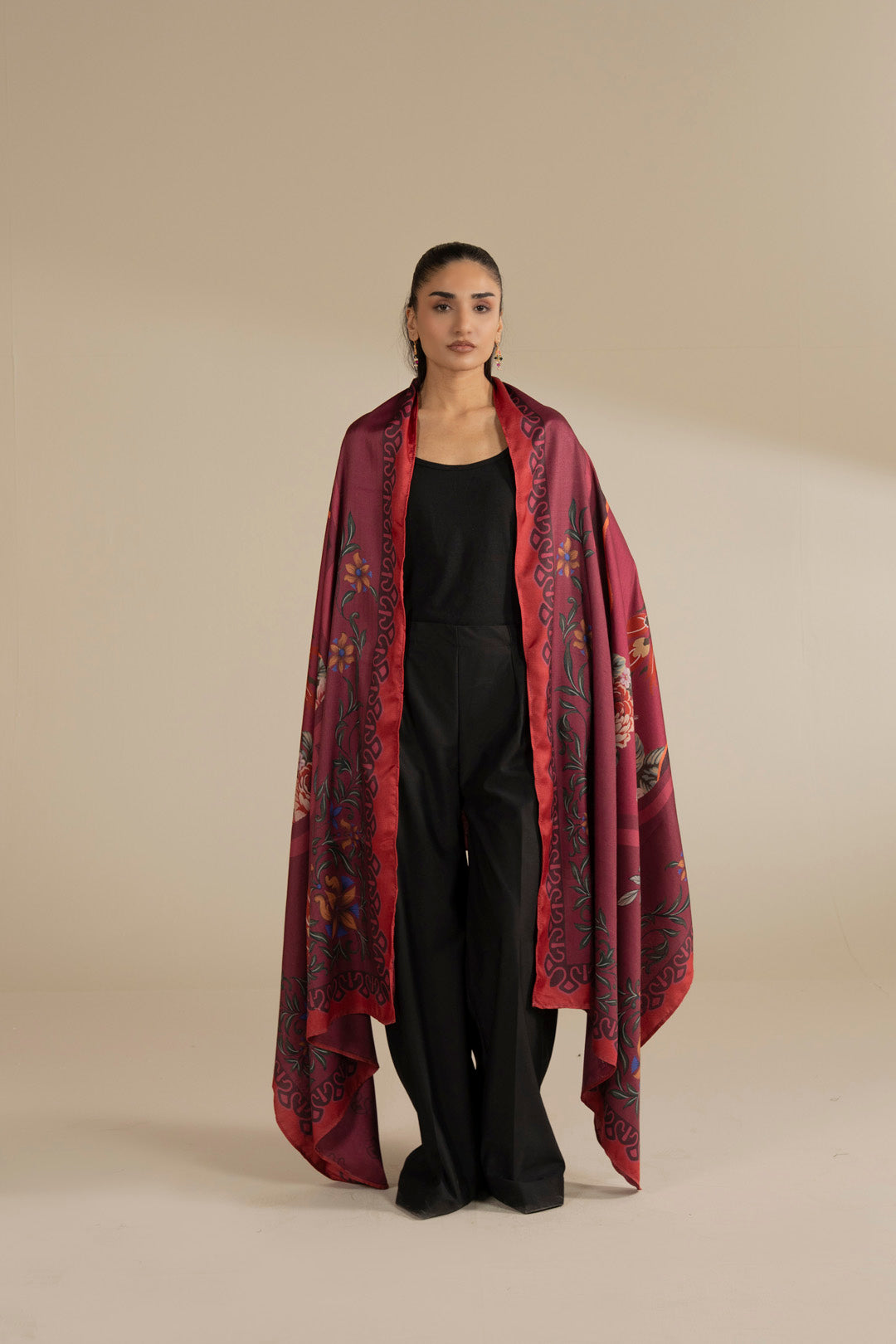 Model wearing maroon floral printed herringbone shawl over black outfit, full front view in studio.
