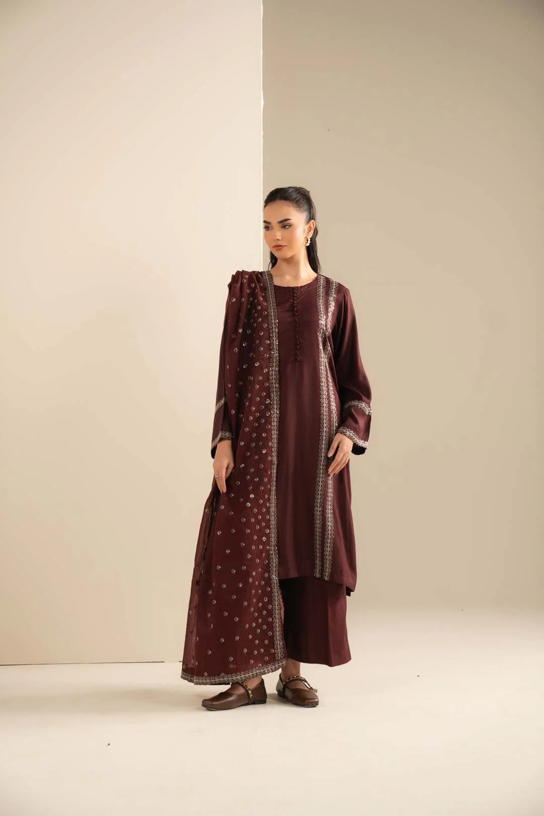 Model wearing maroon raw silk 3 piece ready-to-wear suit with sequin detailing, full front view in studio.