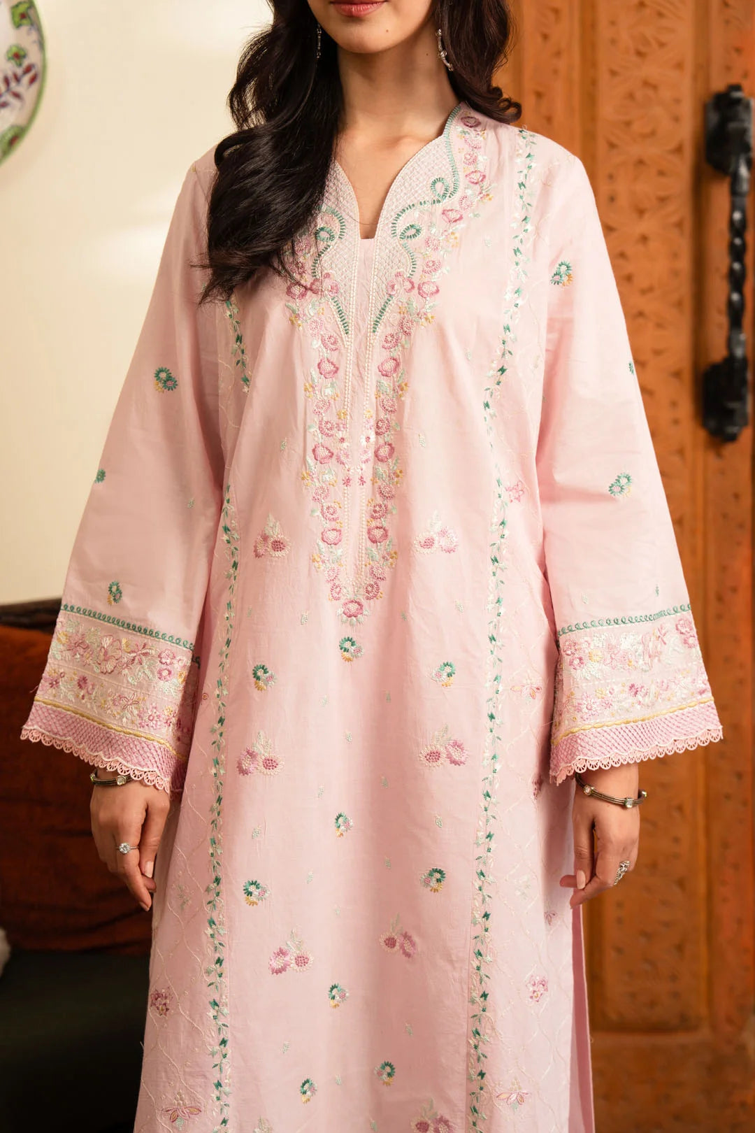 Model wearing pastel pink embroidered lawn shirt with cambric trouser