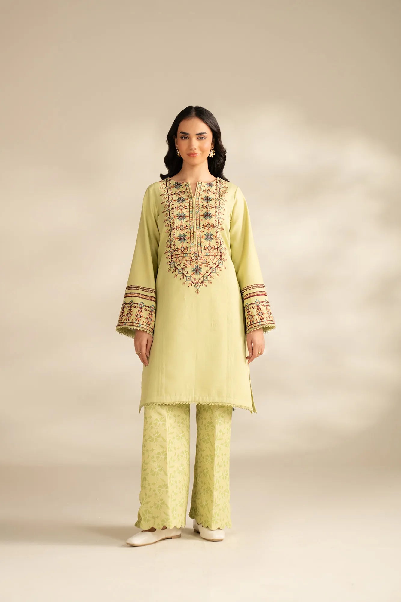 Model wearing unstitched 2 piece embroidered khaddar suit with printed slub trouser