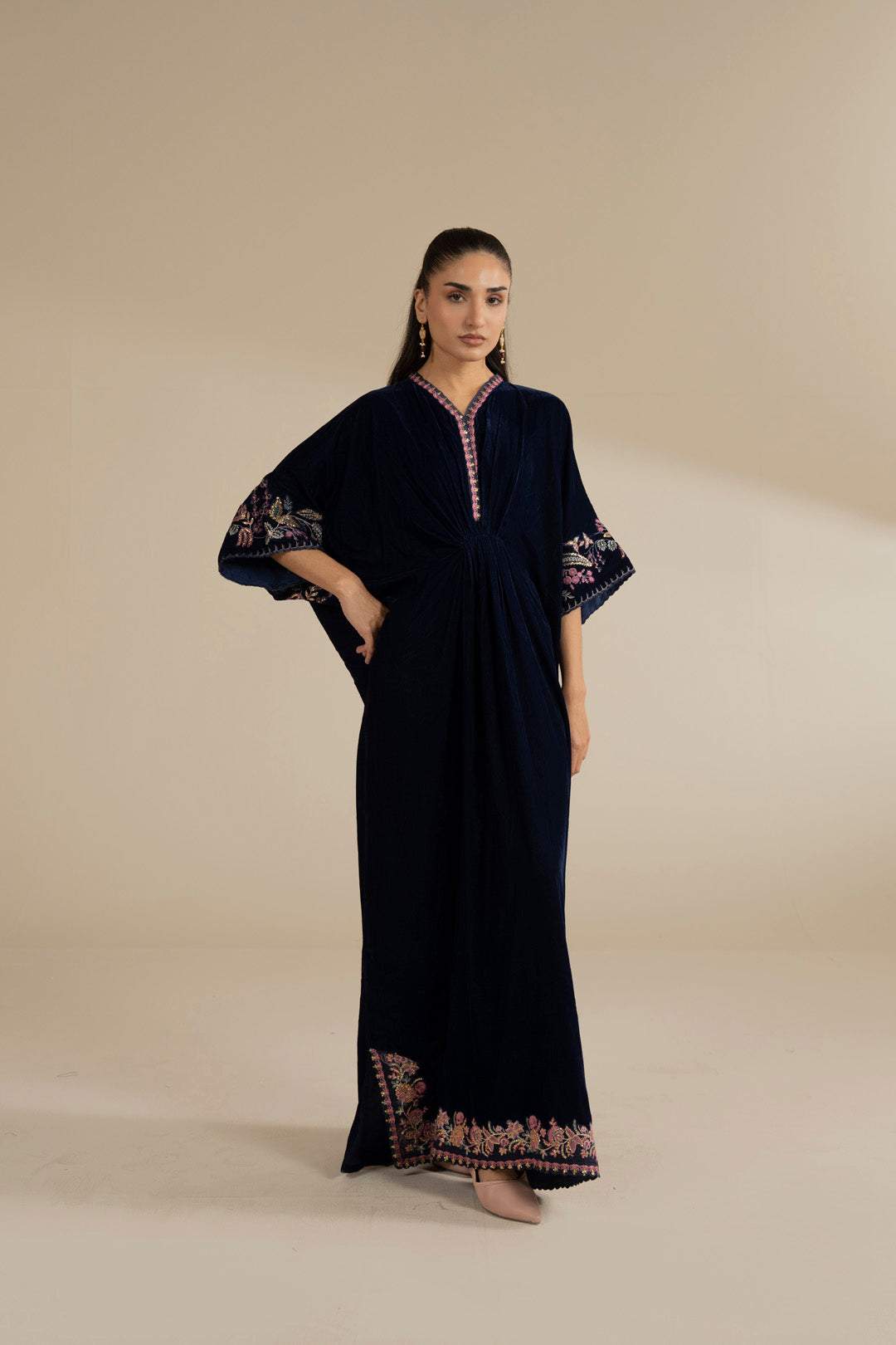 Navy velvet kaftan with embroidered neckline and hem border, shown as a full-length studio look.
