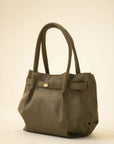 Olive green suede tote bag with double shoulder handles and a soft slouchy silhouette on a neutral background.