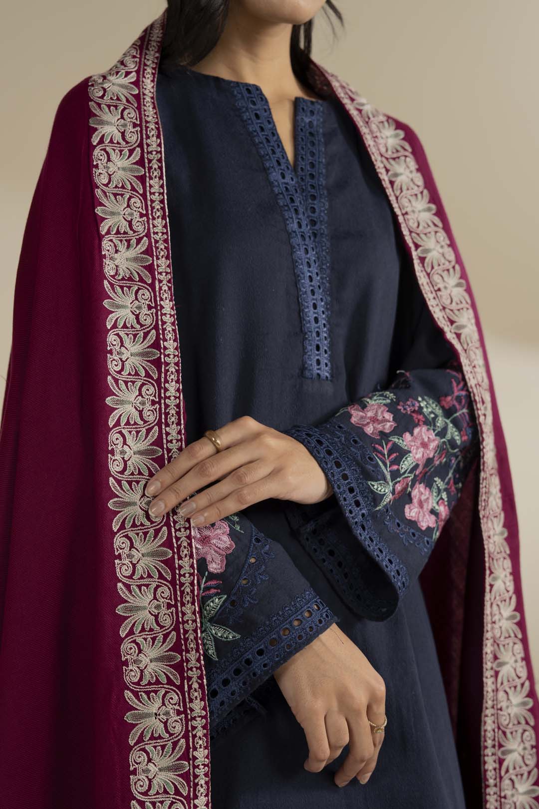 Ornate embroidered border detail on the pink shawl, showing threadwork and edging up close.