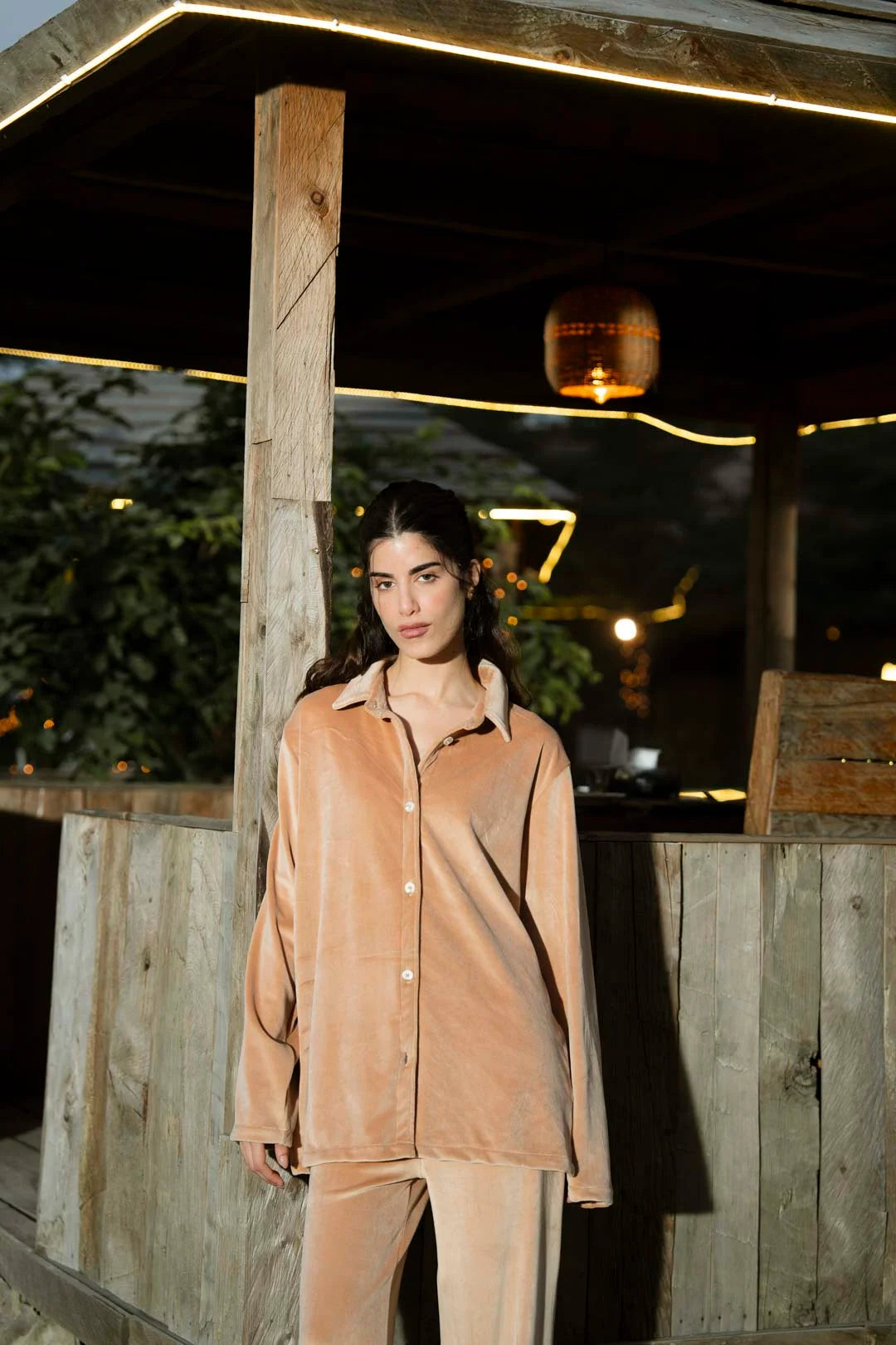 Outdoor portrait in tan velvet co-ord set highlighting relaxed collar and button placket.