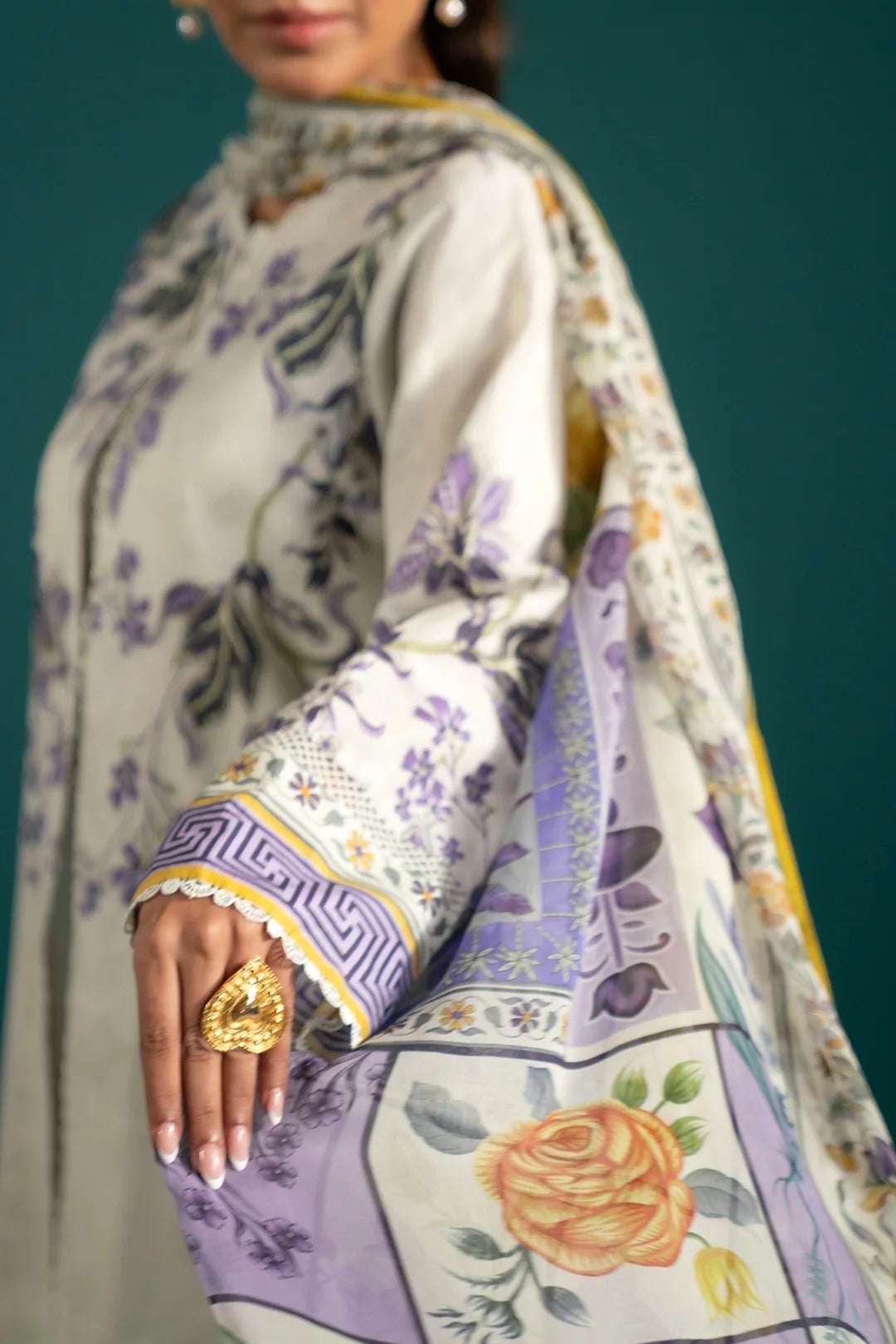 Pakistani lawn suits featuring a sophisticated white and purple floral-printed lawn shirt with an embroidered border and a flowing chiffon dupatta.