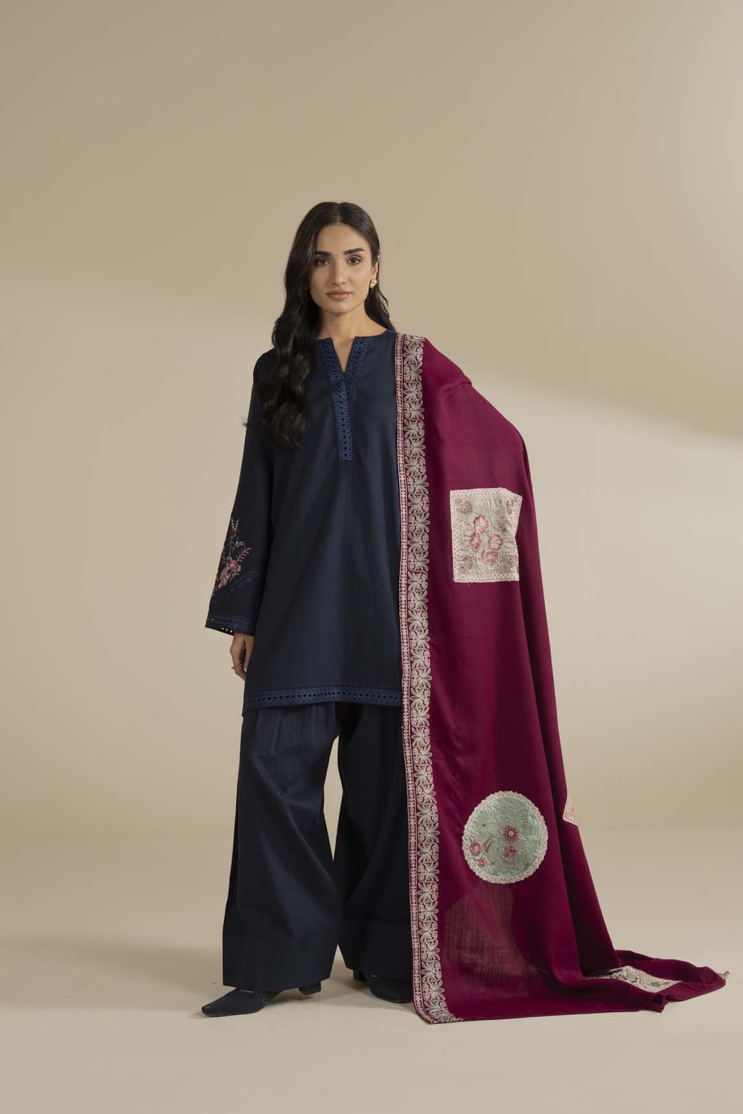 Pink shawl with embroidered border draped over a navy outfit, full look in studio lighting.