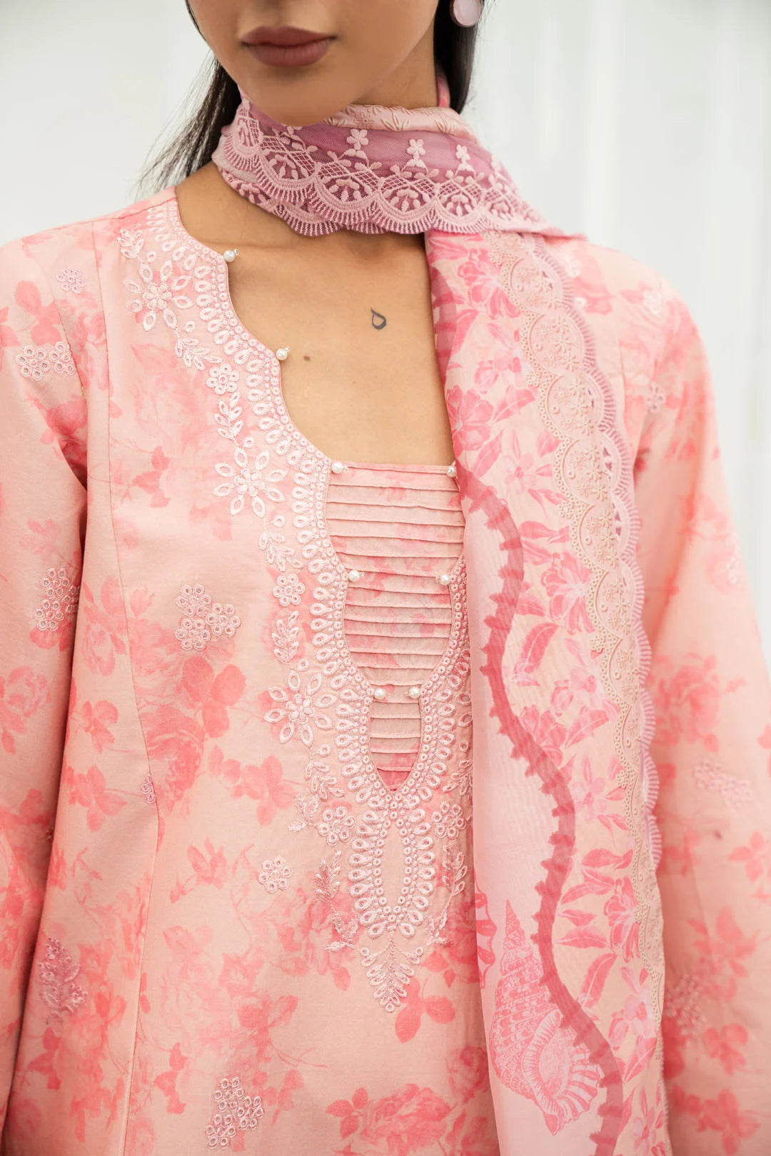 Pink unstitched lawn suit close up all over floral print embroidery neckline bell sleeve detail Pakistan 2026