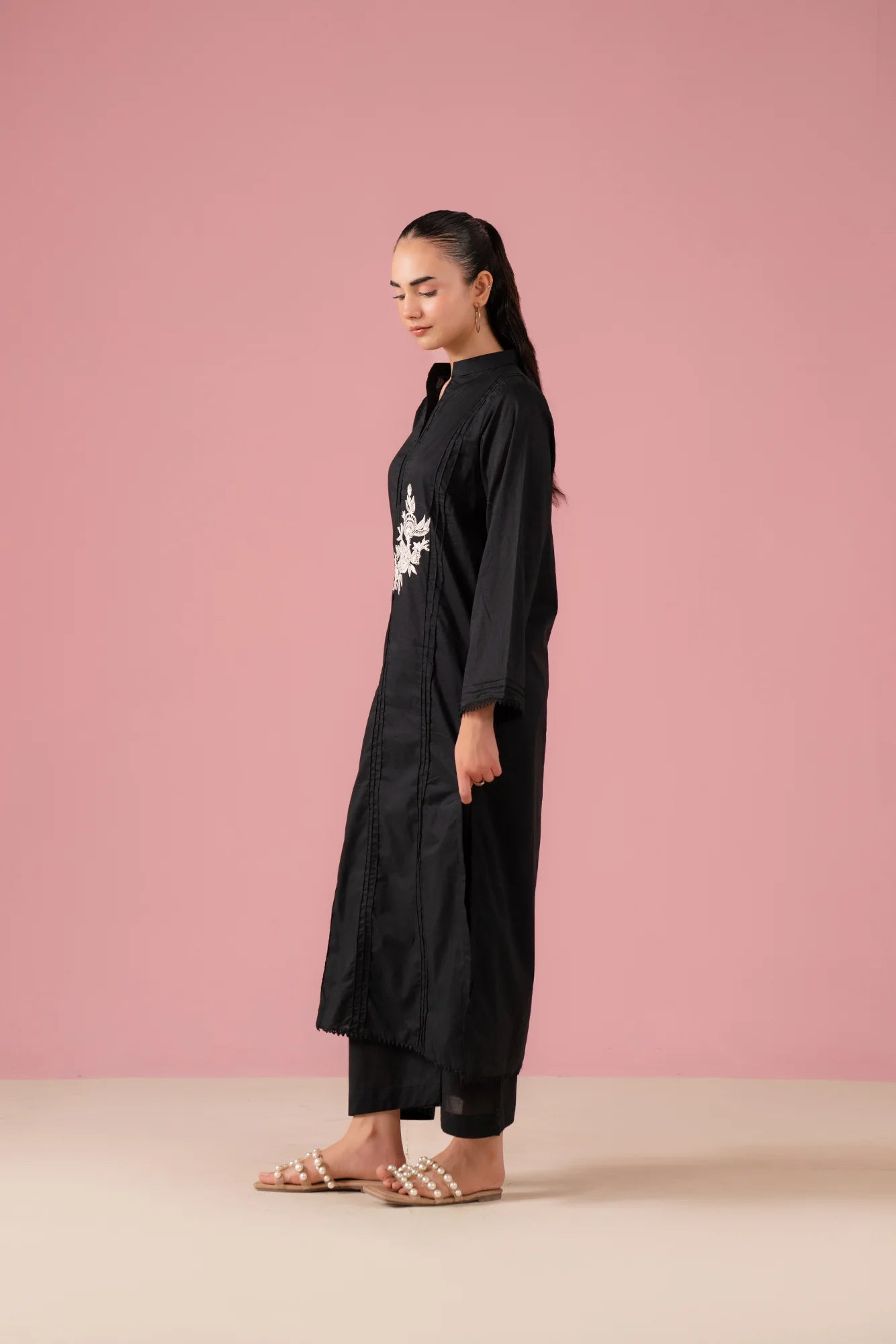 Shop black two-piece co ord set for women in Pakistan with white floral embroidery on kurta and classic black trousers