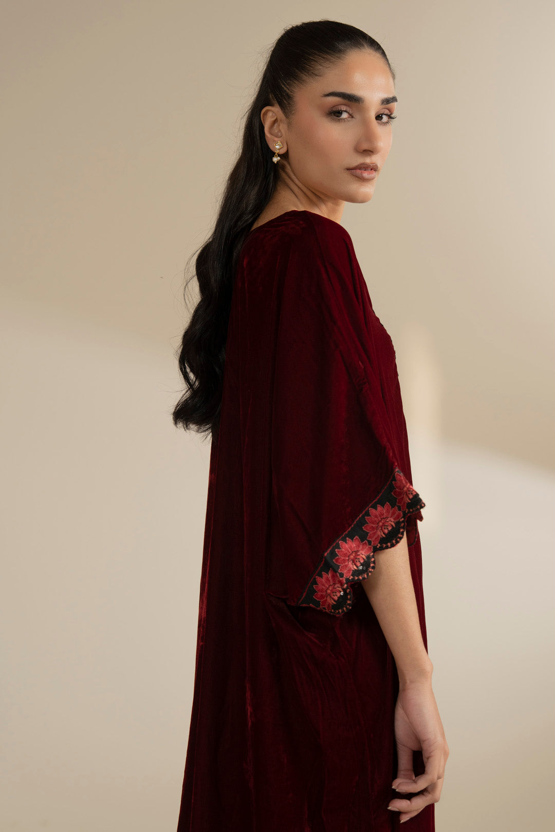 Side angle highlighting the drape of the maroon kaftan and sleeve shape.