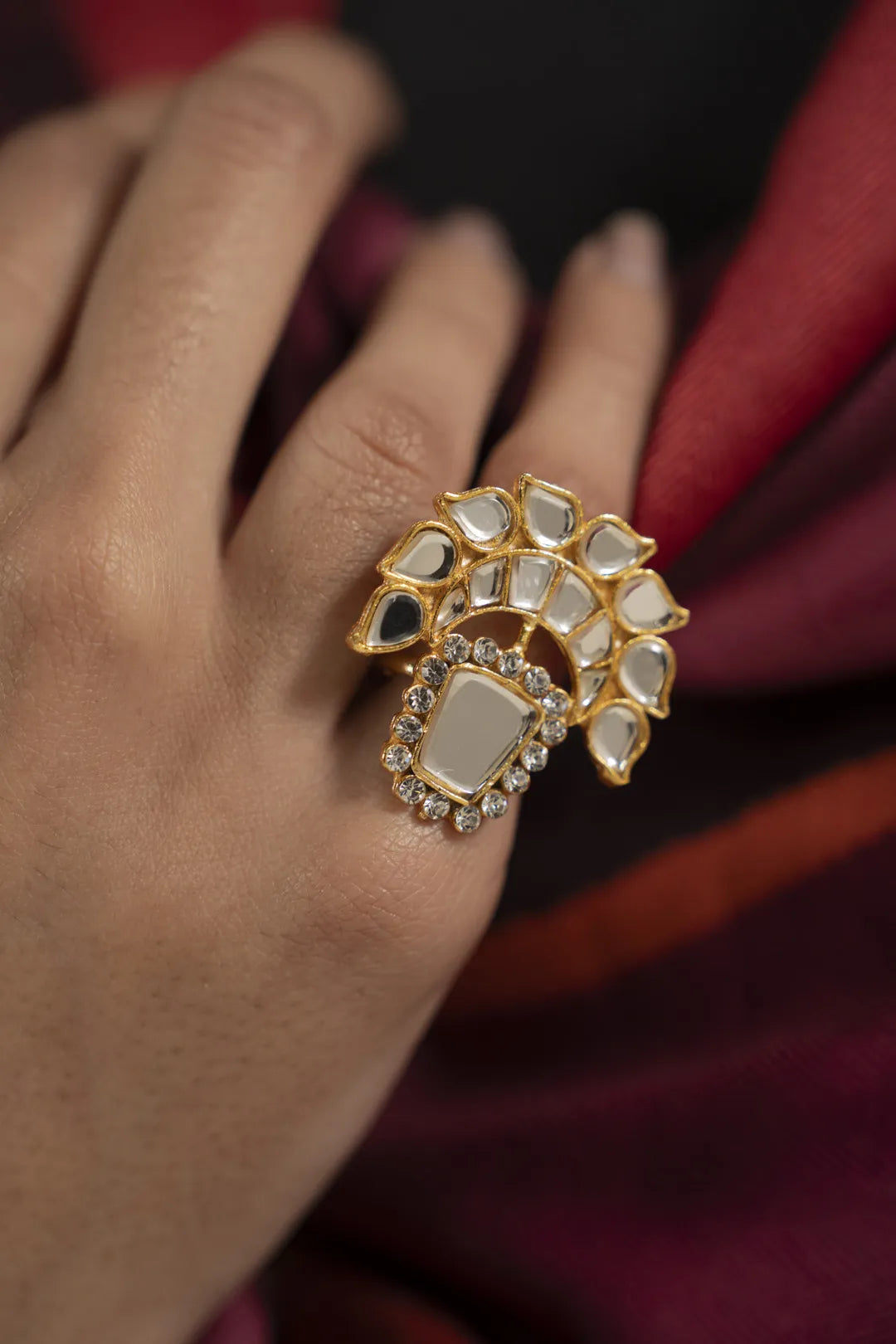 Side angle of kundan ring showing raised setting and bold shine on finger.