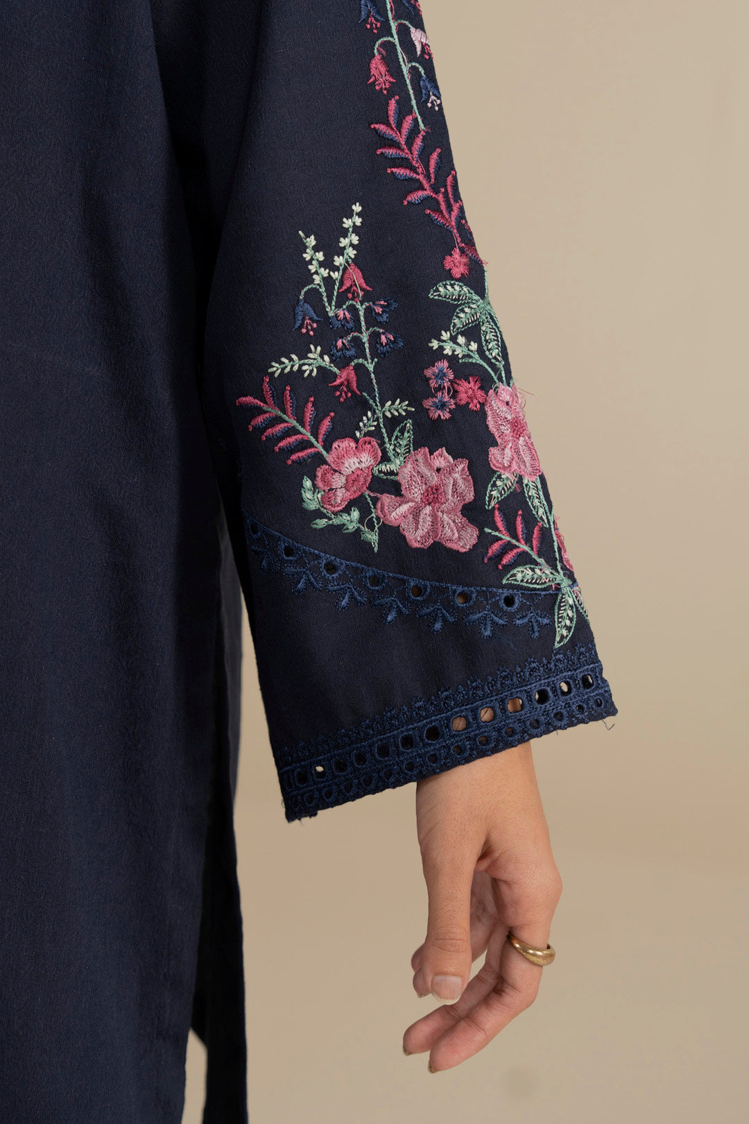 Side close-up of embroidered sleeve on navy blue kurta with floral motifs.
