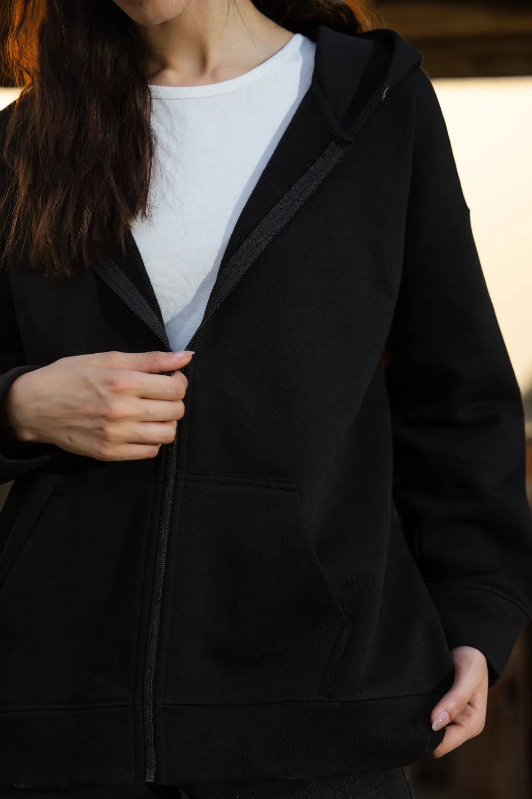 Side detail of black zip hoodie fit and neckline area
