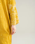 Side detail of mustard embroidered raw silk kaftan sleeve and fabric texture
