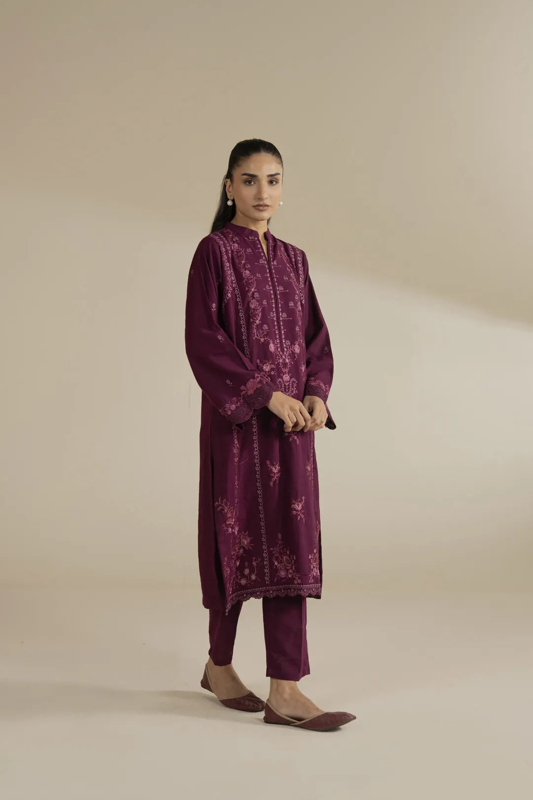 Side pose of embroidered khaddar shirt with matching trousers in deep pink tone.