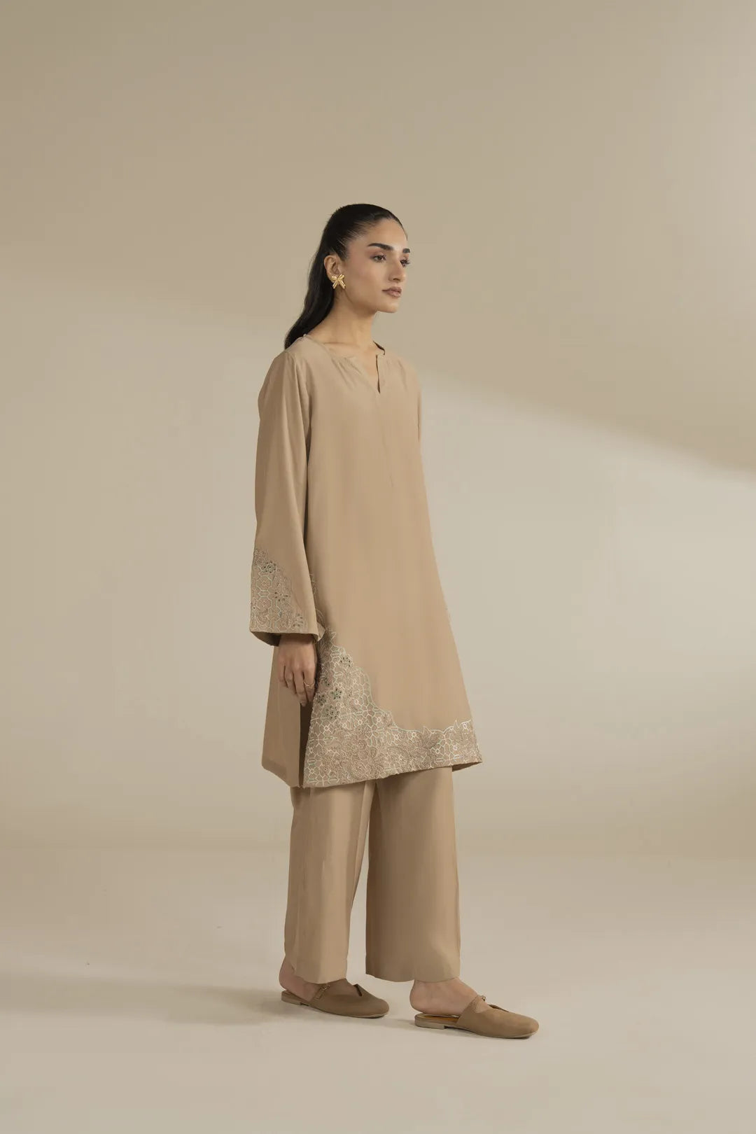 Side pose of minimalist beige kurta and trouser set for women, soft blended fabric.