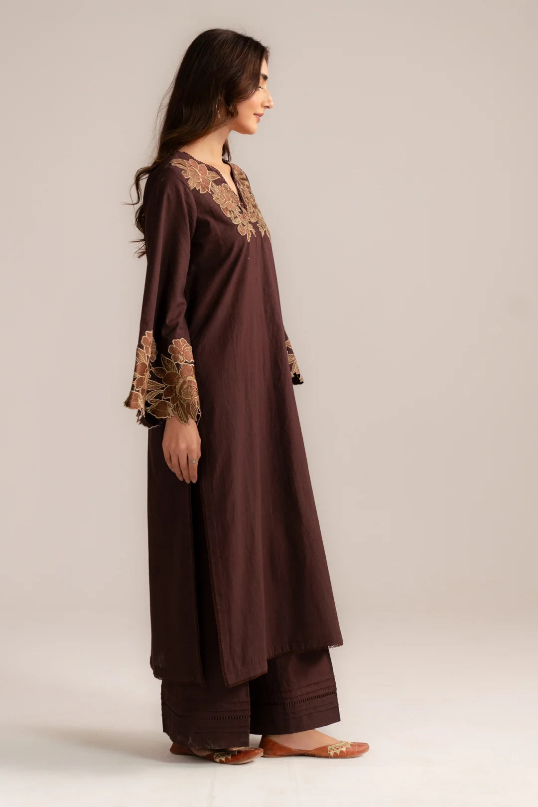 Side profile of brown embroidered pret suit with detailed sleeve borders