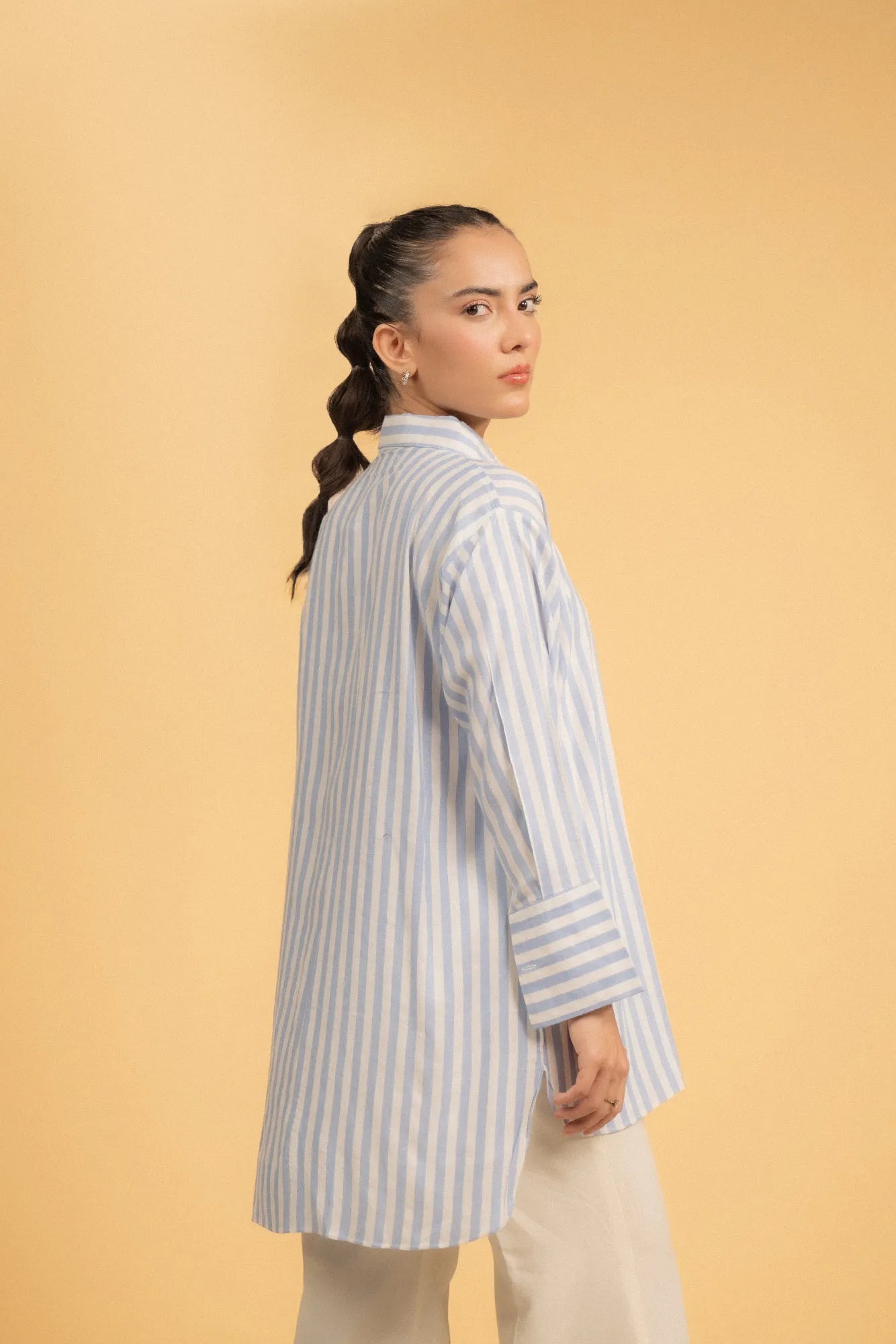 Side view of a striped high-low hem shirt, highlighting the relaxed fit and silhouette