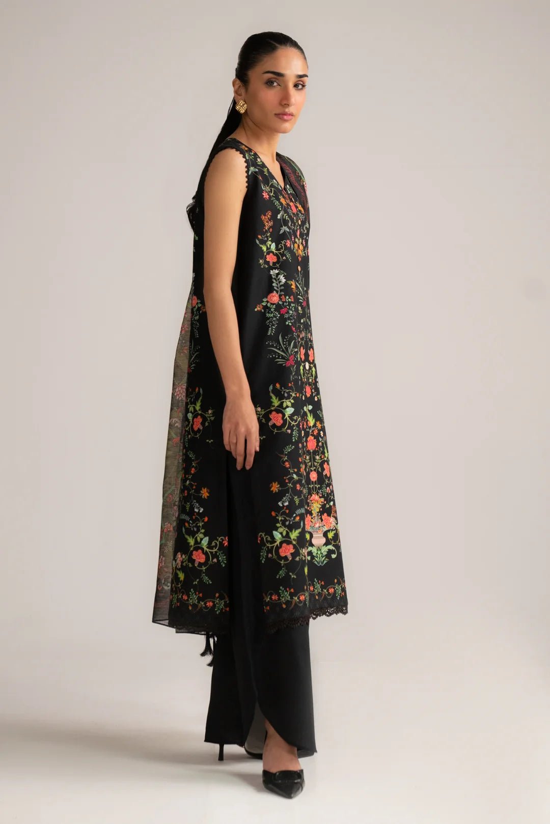 Side view of black lawn suit with flowing voile dupatta and dark trousers