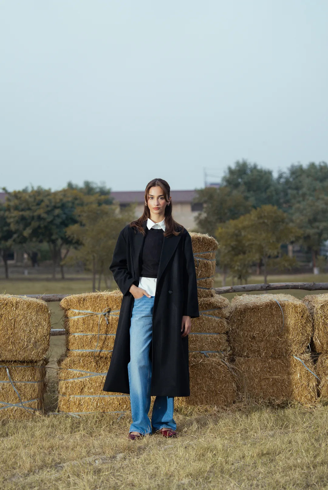 Side view of black long coat showing drape and straight silhouette