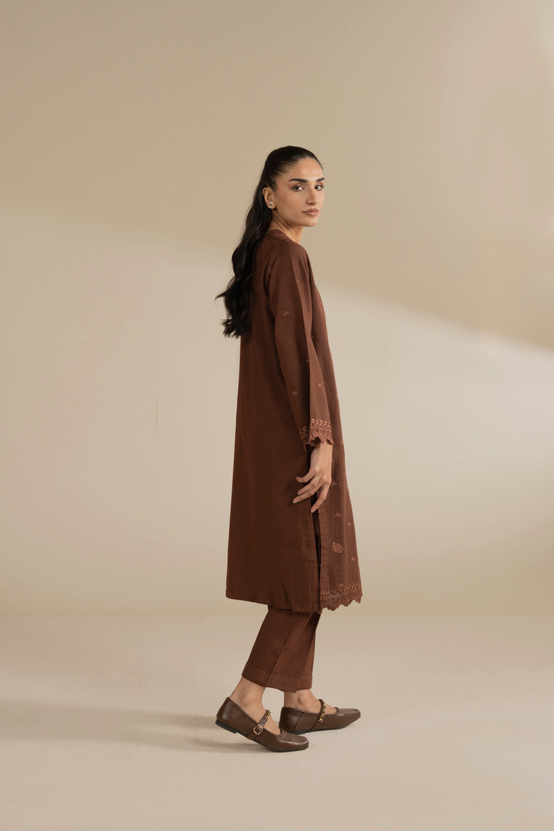 Side view of brown embroidered ready-to-wear suit showing kurta length and silhouette.