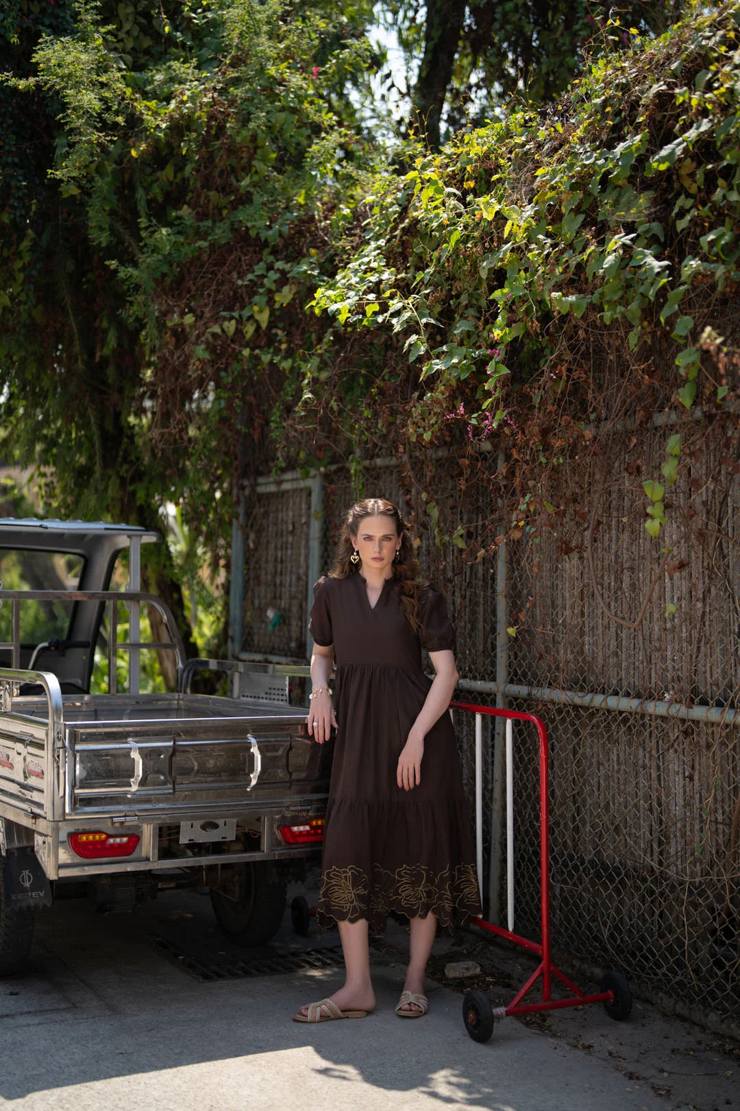 Side view of dark brown cambric frock with embroidered border