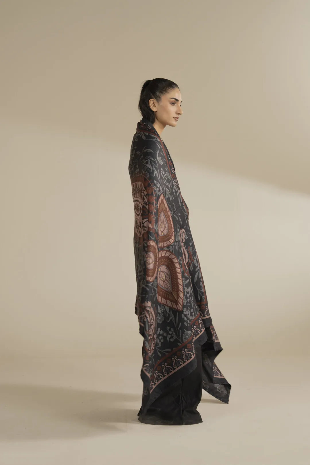 Side view of grey printed shawl wrapped around shoulders, showing overall length and border design