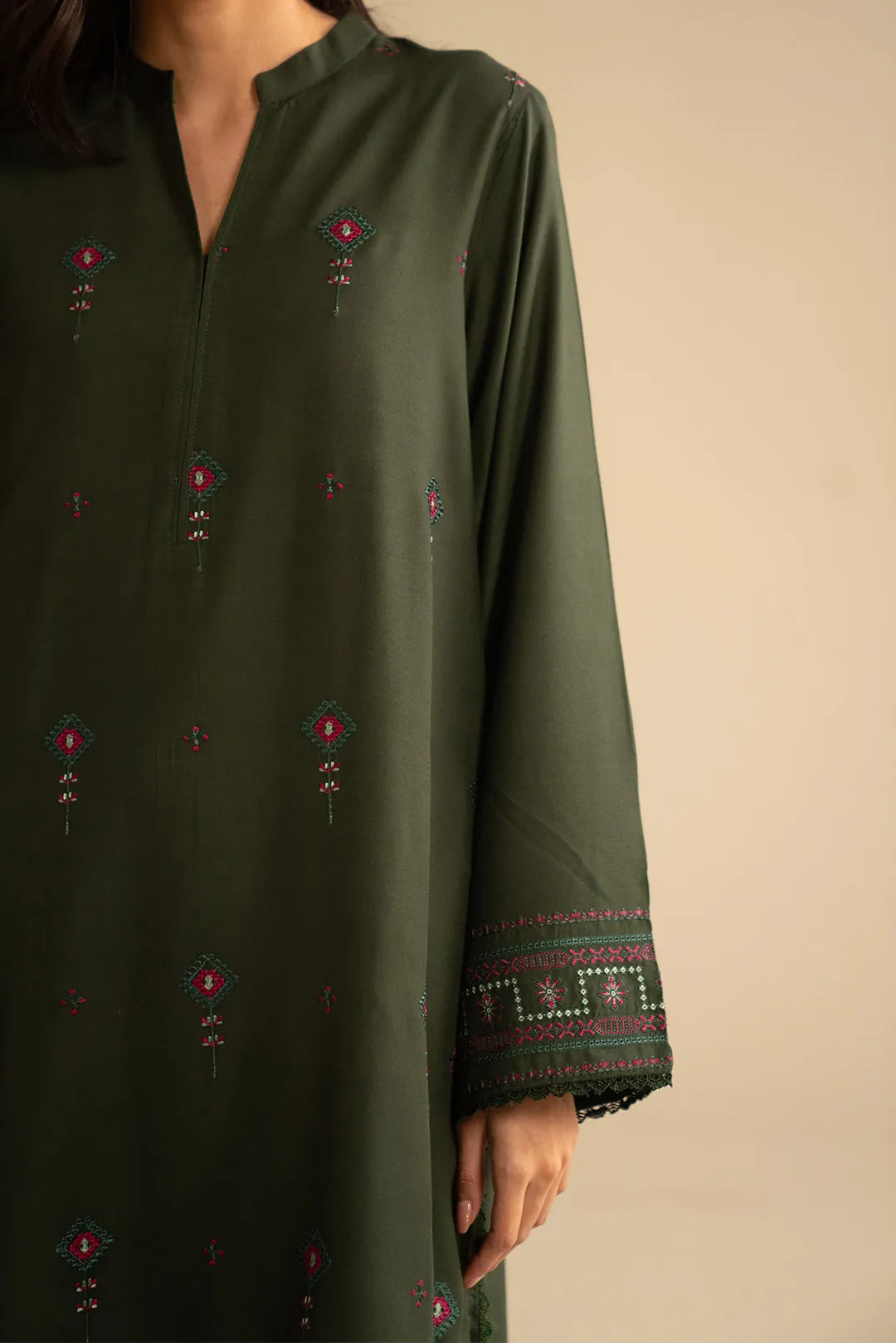 Sleeve close-up of green linen suit highlighting embroidery and cuff finishing.