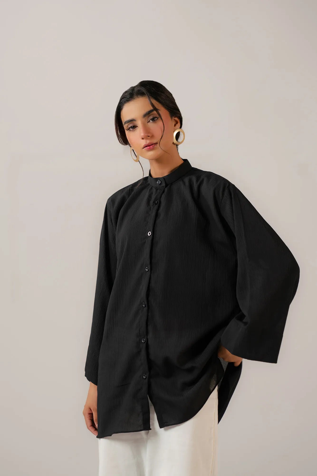 Stylish oversized black shirt for women paired with casual white pants