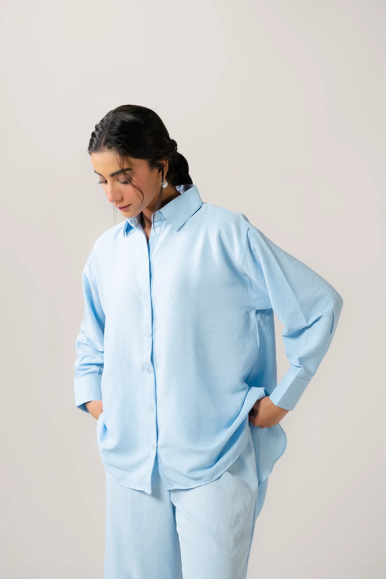 Stylish woman wearing a black ladies poplin shirt with a unique mandarin collar, paired with tailored trousers for a modern look