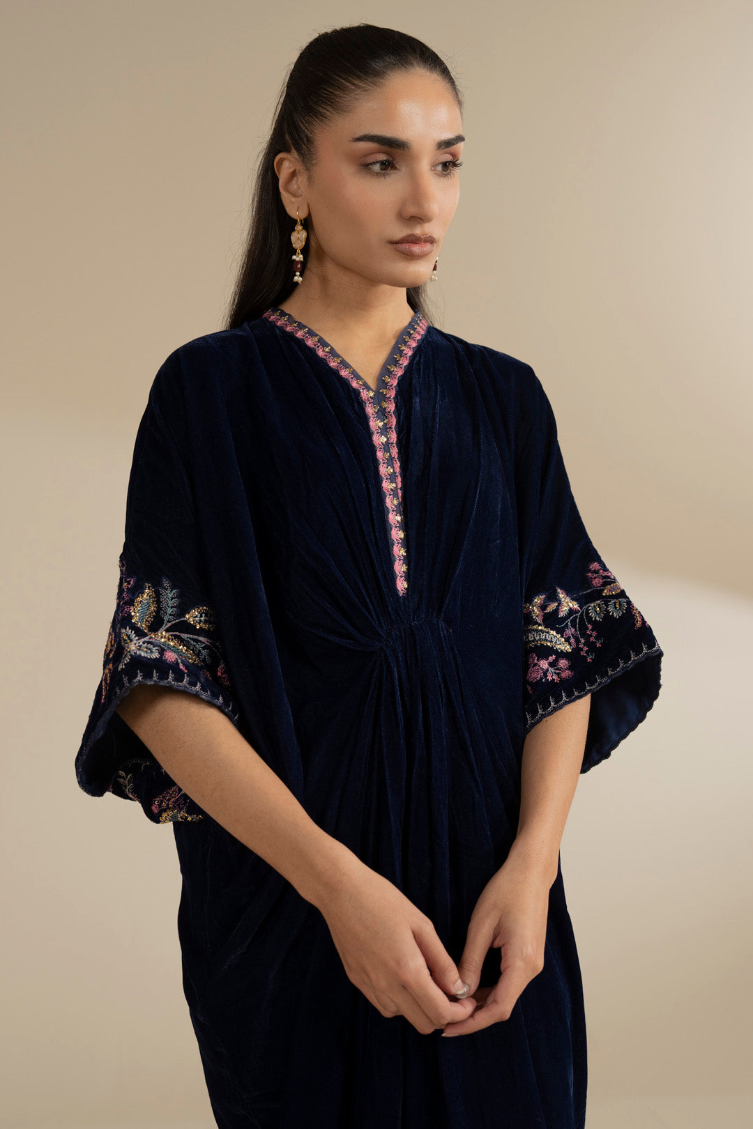 Three-quarter pose highlighting relaxed kaftan drape and wide sleeve shape.