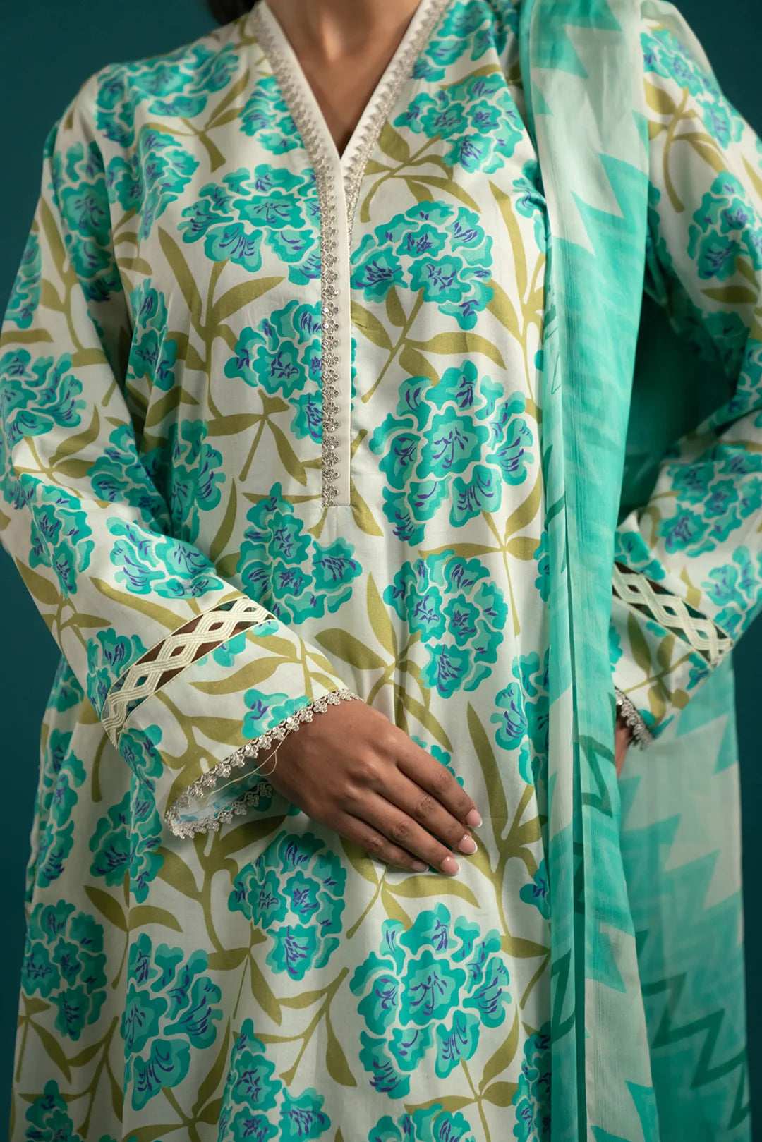 Upgrade your wardrobe with this stylish unstitched lawn suit – a soft off-white and aqua floral ensemble with a striking chiffon dupatta.